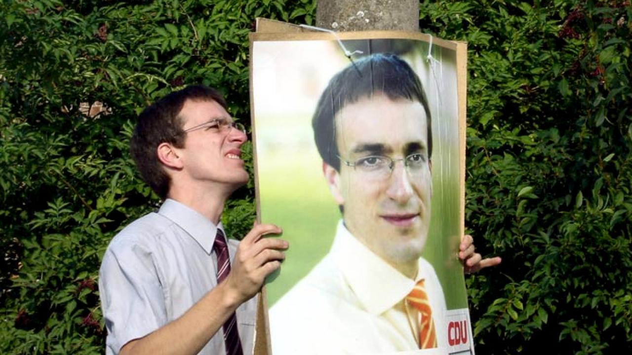 Filmstill aus dem Dokumentarfilm HERR WICHMANN VON DER CDU: Der Politiker Henryk Wichmann hängt ein Wahlplakat auf.