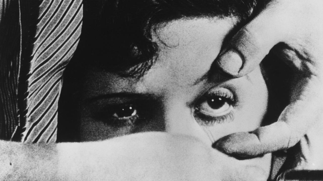 Filmstill aus EIN ANDALUSISCHER HUND: Nahaufnahme: das Gesicht einer Frau. Eine Männerhand hält ihr Augen offen. In der anderen Hand hält er ein Rasiermesser.