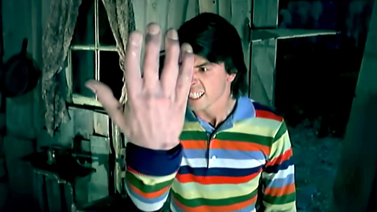 Screenshot aus dem Musikvideo EVERLONG von den Foo Fighters: Ein Mann hält seine übergroße Hand vor sich und schaut grimmig.