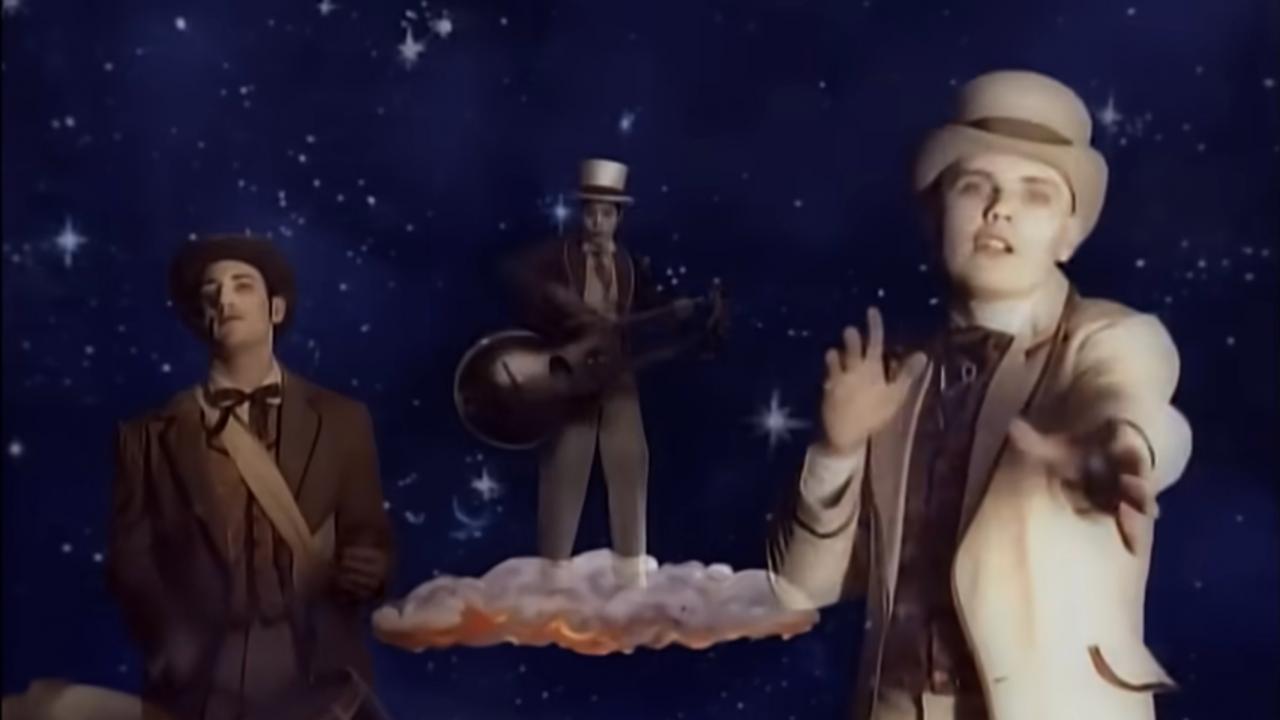 Still aus dem Musikvideo TONIGHT, TONIGHT von The Smashing Pumpkins: Der Sänger Billy Corgan und zwei weitere Musiker stehen, gekleidet im Stil um 1900, im Weltall auf stilisierten Wolken.