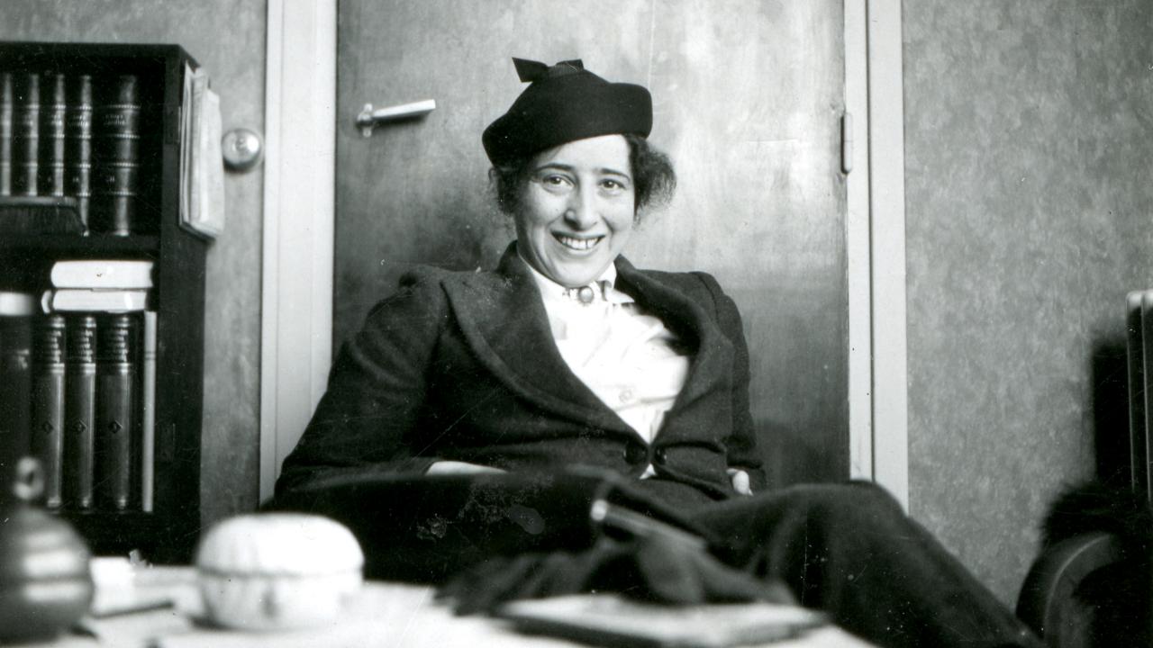 Still aus dem Dokumentarfilm HANNAH ARENDT: DENKEN IST GEFÄHRLICH: Privataufnahme von der Philosophin Hannah Arendt, die lächelnd an einem Tisch sitzt.