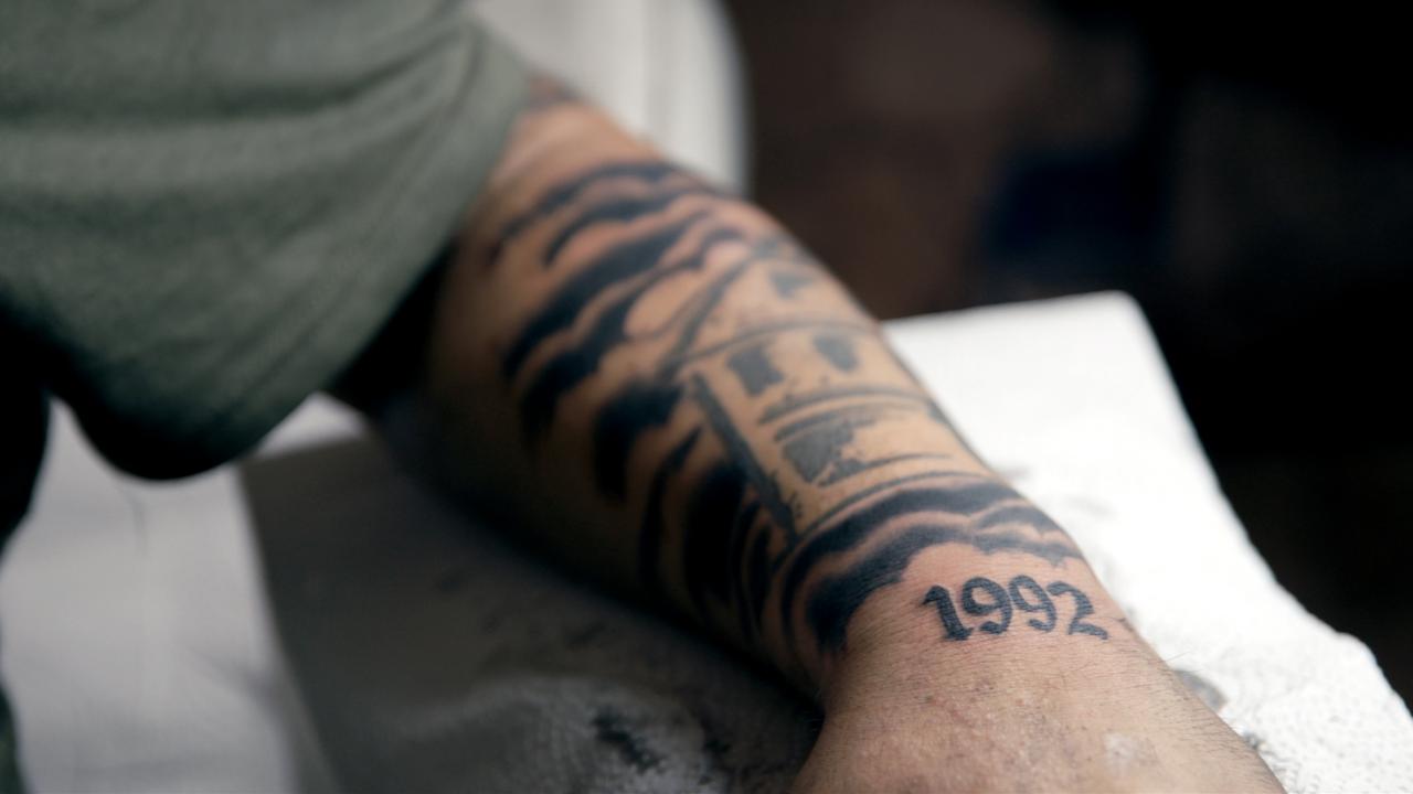 Still aus dem Dokumentarfilm DIE MÖLLNER BRIEFE: Bild des linken Unterarms von Namık Arslan, einem Überlebenden des rassistischen Brandanschlags von 1992. Er hat sich darauf ein Bild des Hauses nach dem Anschlag sowie die Jahreszahl 1992 tätowieren lassen.