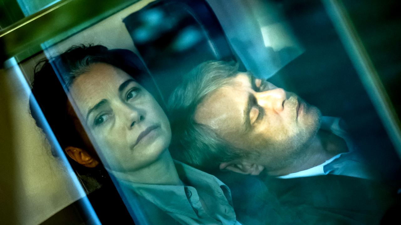 Still aus dem Drama GELBE BRIEFE: Blic von außenk in ein Zugabteil, in dem eine  Frau und ein Mann mittleren Alters sitzen. Die Frau schaut ernst aus dem Fenster. Der Mann schläft. Das Bild ist gekippt.