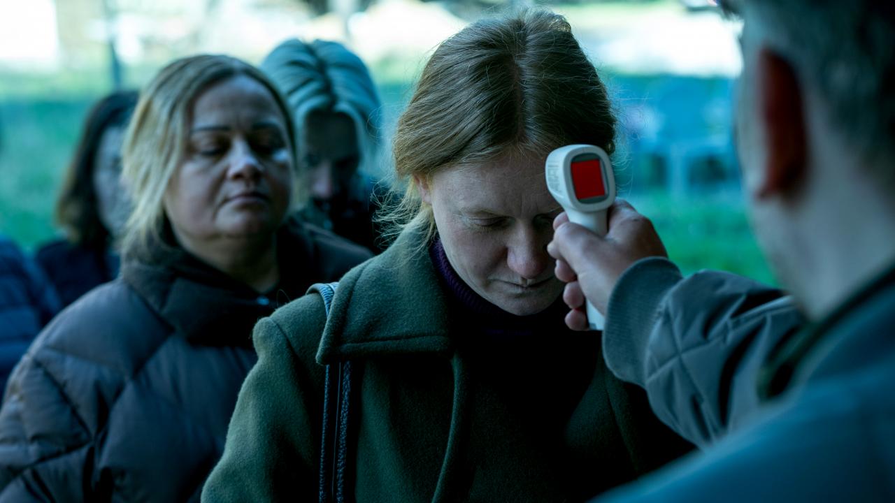 Still aus dem Drama MADE IN EU: Frauen stehen in einer Reihe. bei der ersten wird Fieber gemessen.