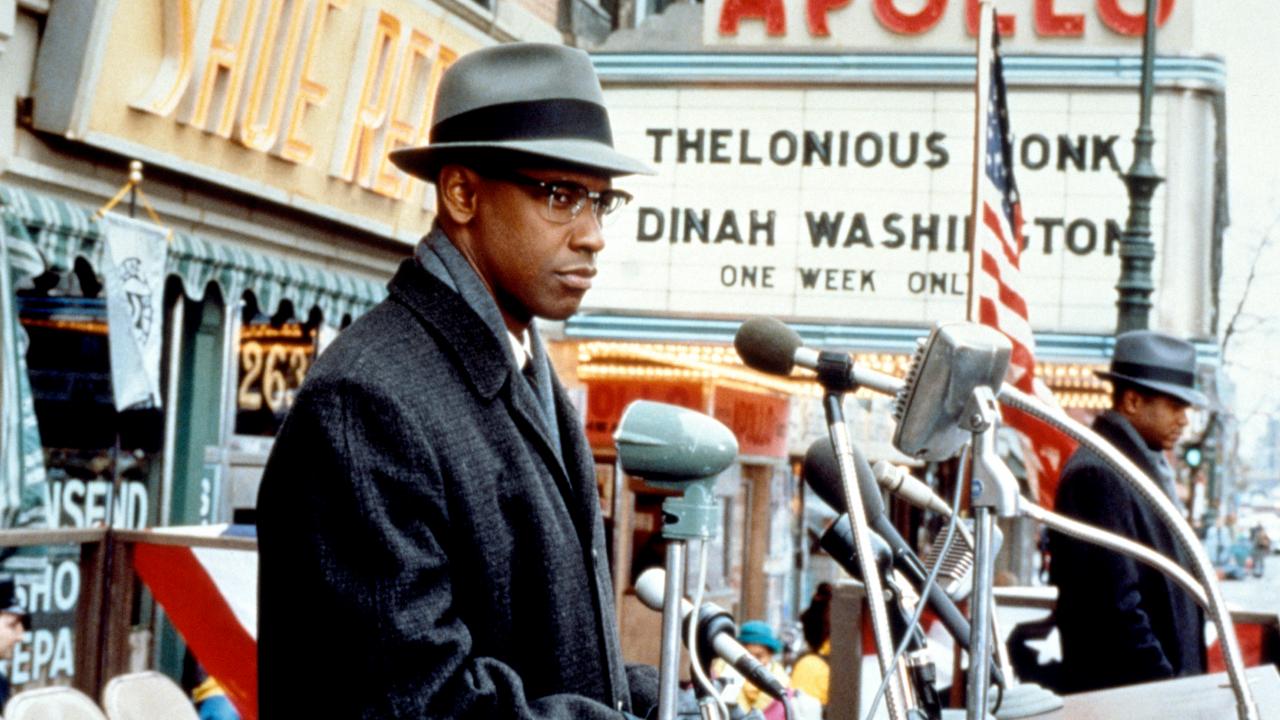 Still aus dem Biopic MALCOM X:mMalcom X, dargestellt von Denzel Washington, steht vor dem Apollo Theater und hält eine Rede.