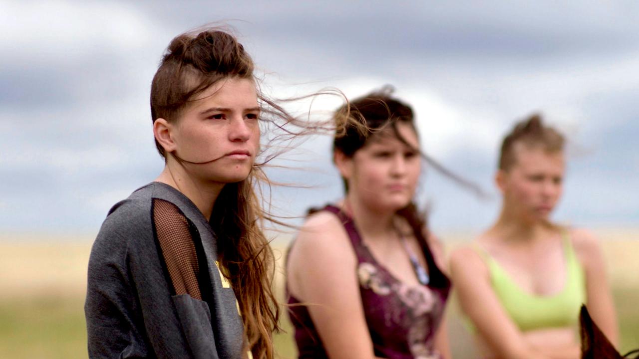 Still aus dem Drama THE NEW WEST: Drei Mädchen im Teenageralter sind nebeneinander zu sehen. Sie schauen ernst. Der Wind weht in ihren Haaren. Hinter ihnen ist eine weite Prärie zu erkennen.