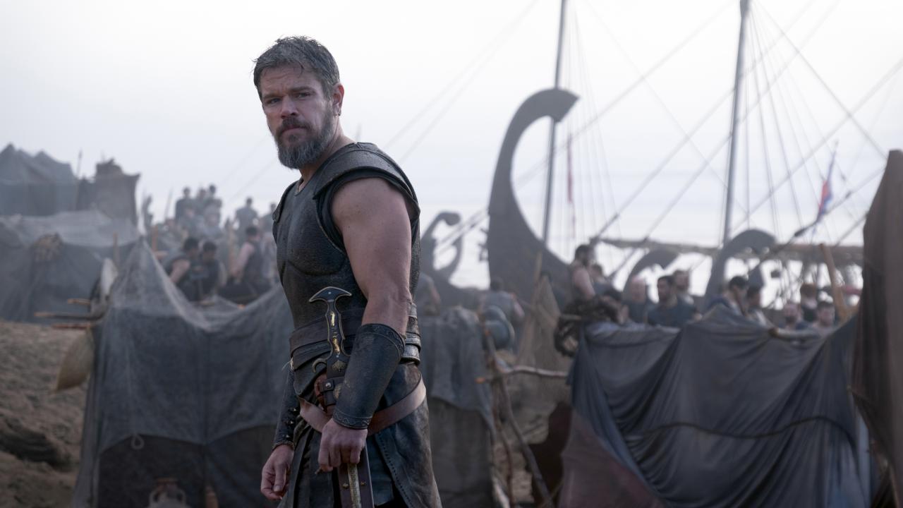 Still aus dem Drama DIE ODYSSEE: Der US-Schauspieler Matt Damon in der Rolle des Odysseus. Im Hintergrund sind Krieger und Boote zu erkennen.