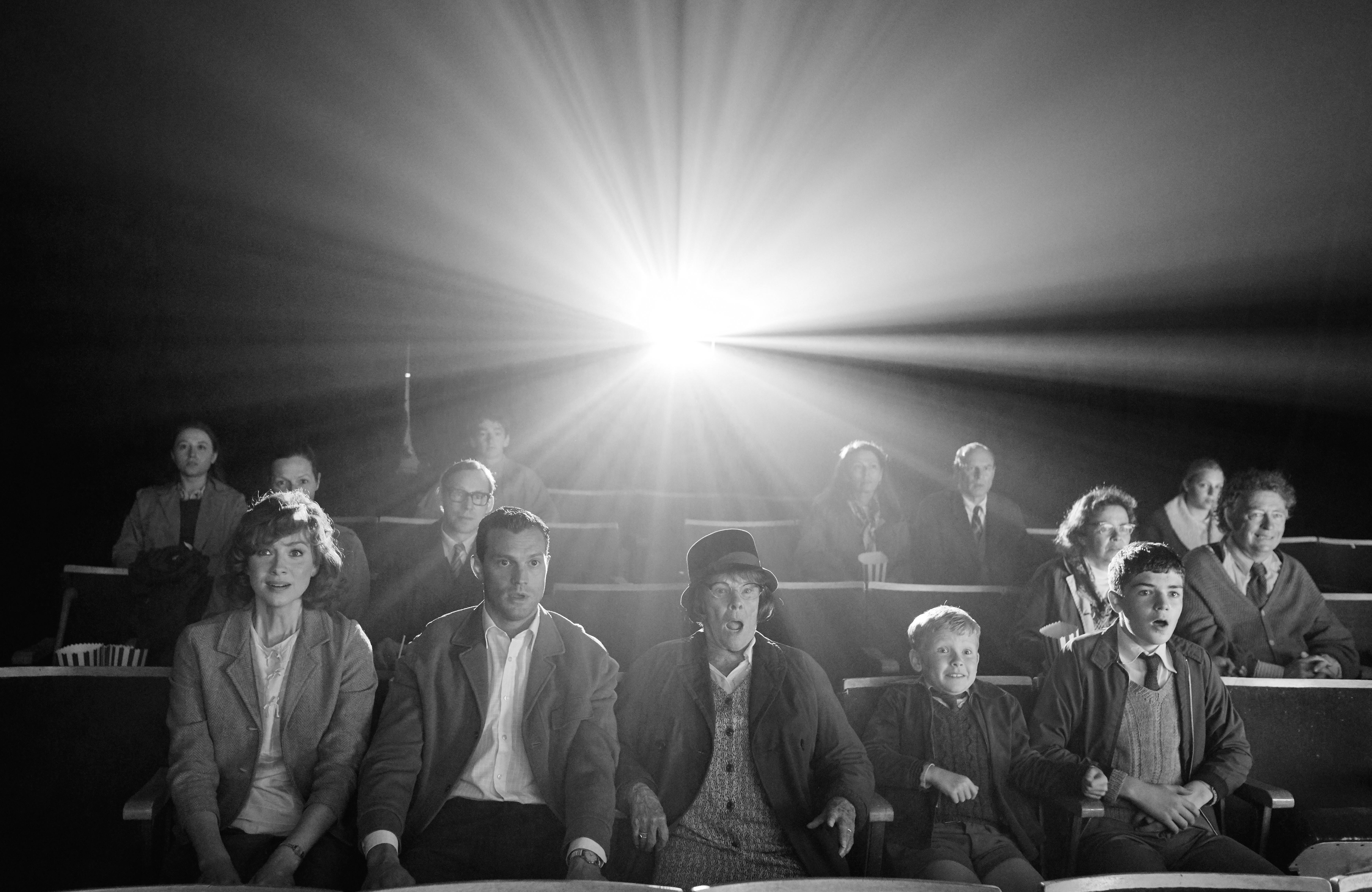  Eine Familie sitzt lachend in einem Kino
