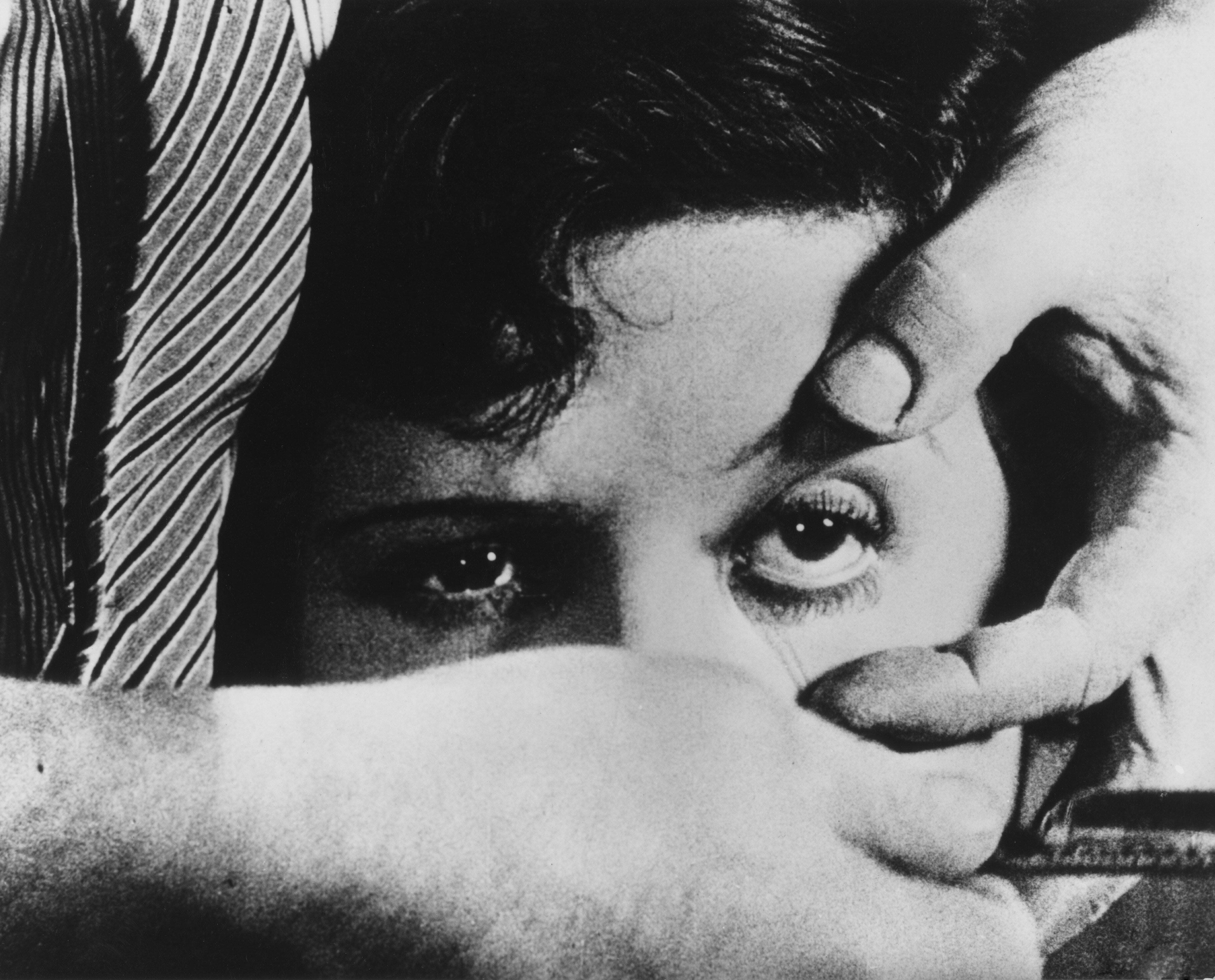Filmstill aus EIN ANDALUSISCHER HUND: Nahaufnahme: das Gesicht einer Frau. Eine Männerhand hält ihr Augen offen. In der anderen Hand hält er ein Rasiermesser.