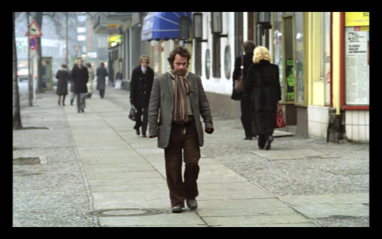 Stroszek, Szenenbild: Ein Mann geht in Berlin auf einem Bürgersteig.